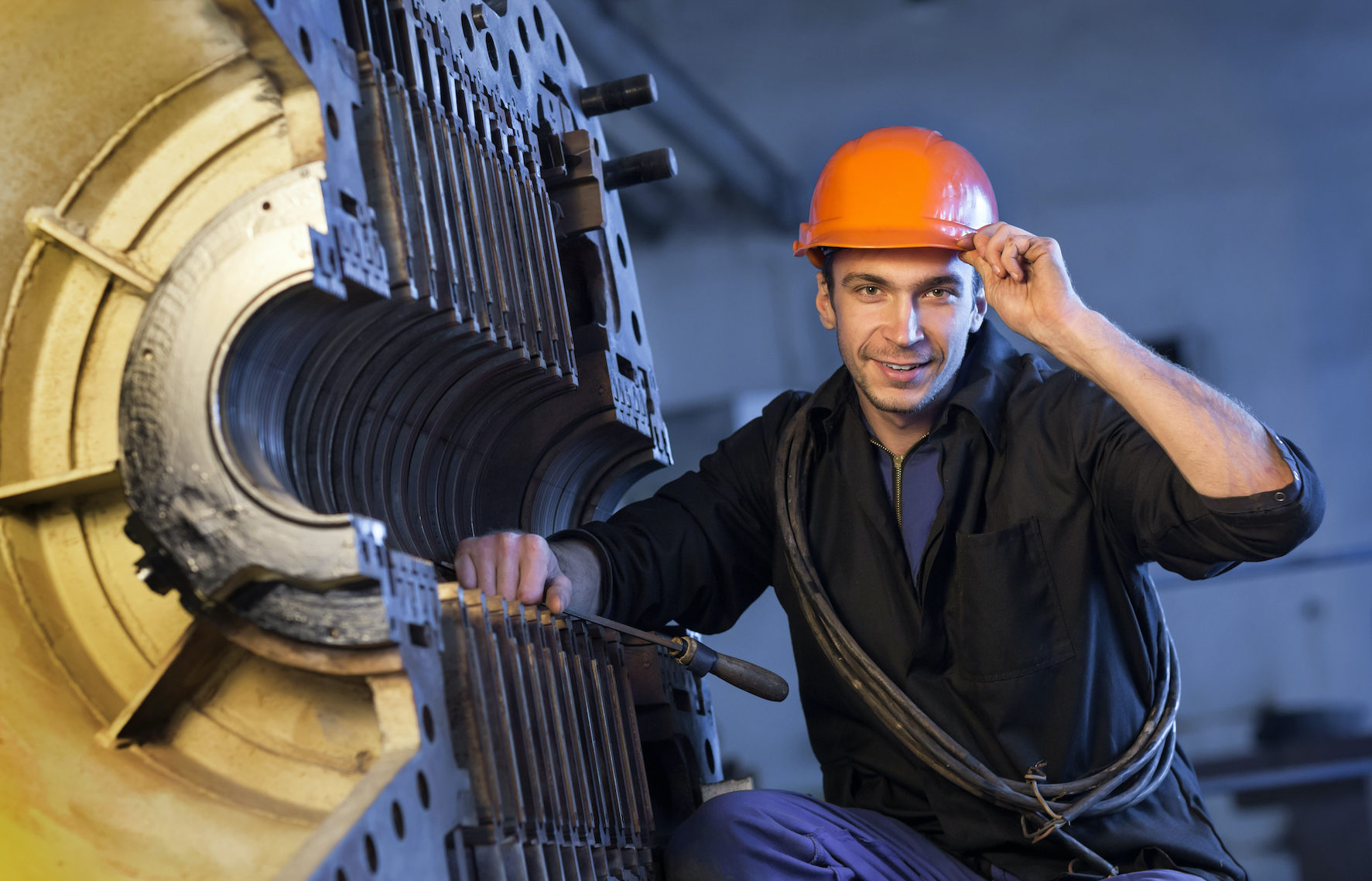 Worker in the helmet near the steam turbine.