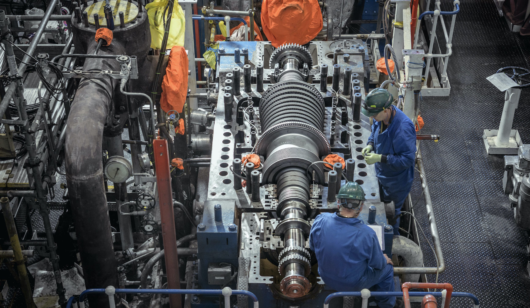 Overhead view of engineers inspecting a turbine in a nuclear power station.