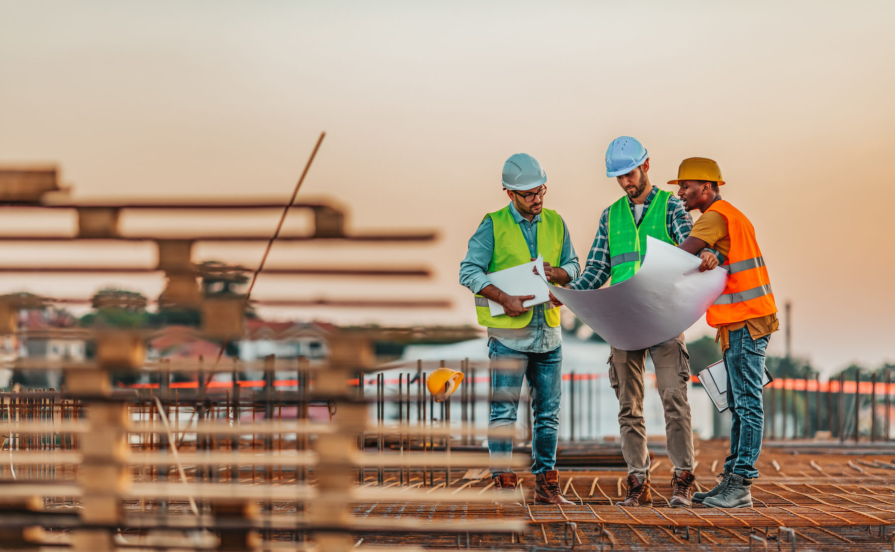 Manual workers talking with an architect while going through housing plans