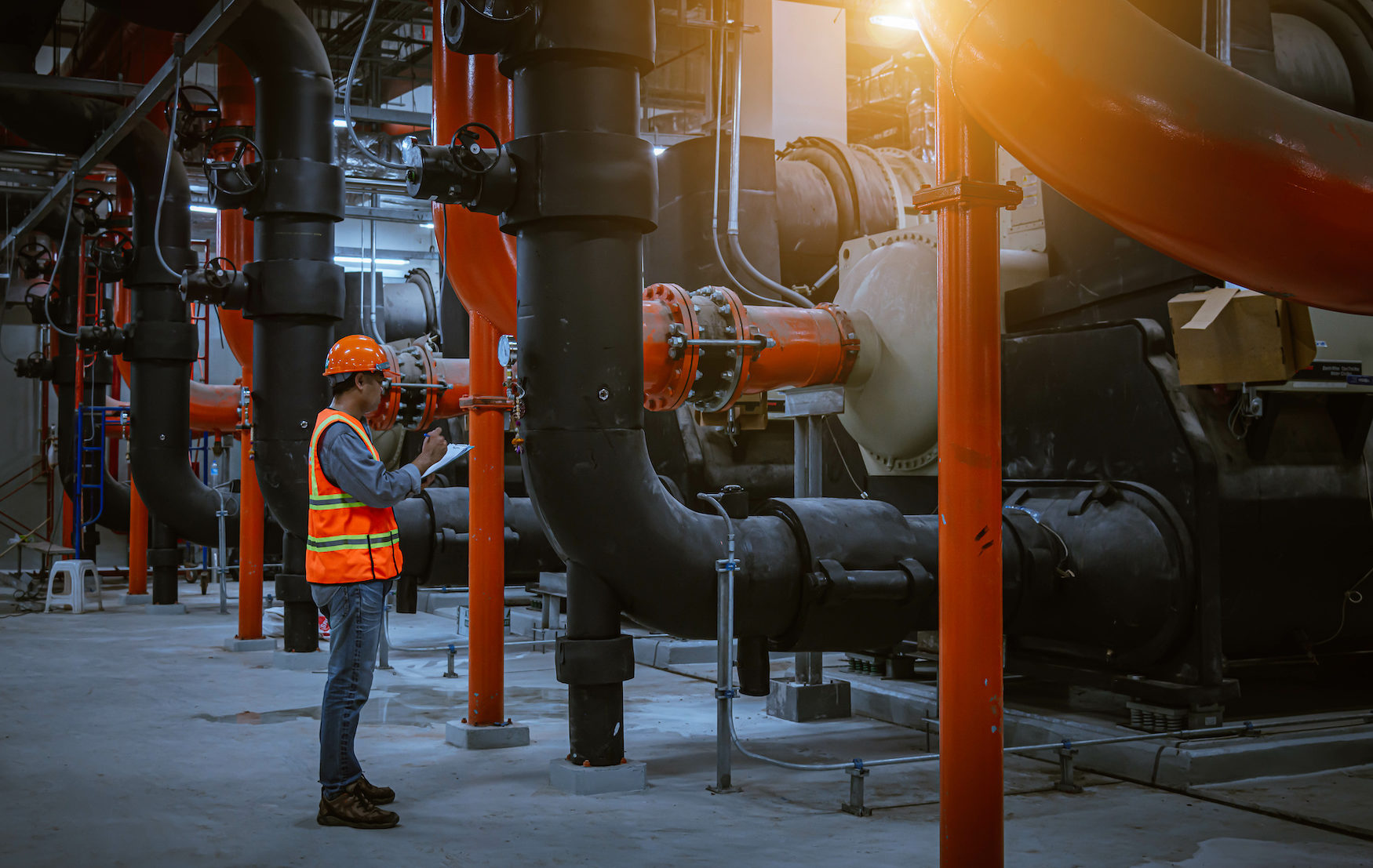 A engineer under checking the industry cooling tower air conditioner is water cooling tower air chiller HVAC of large industrial building to control air system.