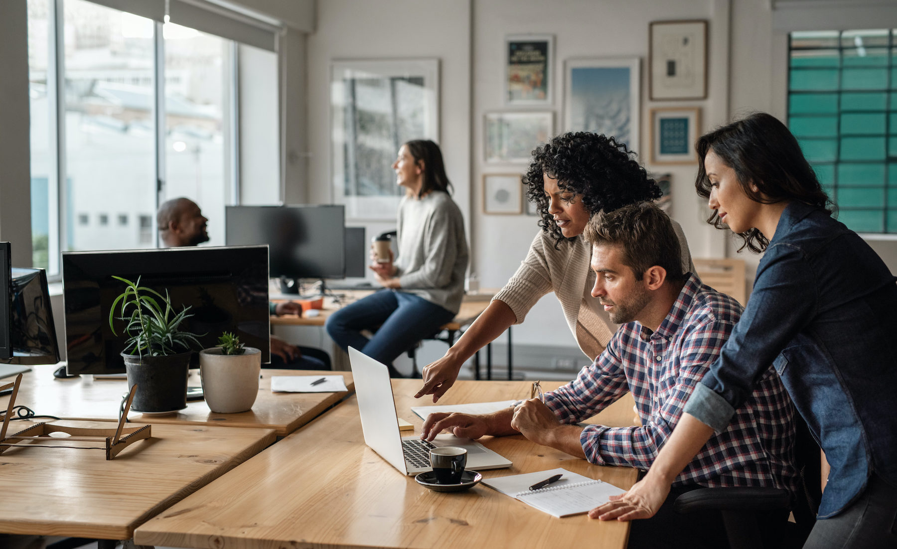 Three young designers using a laptop together at work