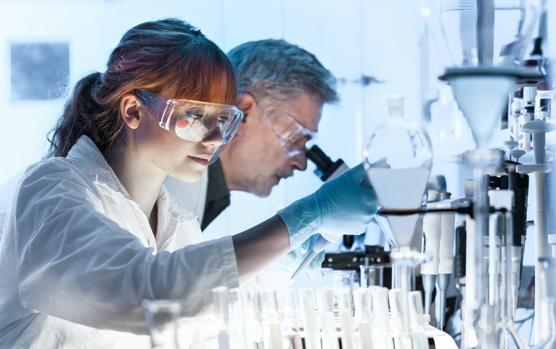 Scientists analyzing samples under a microscope