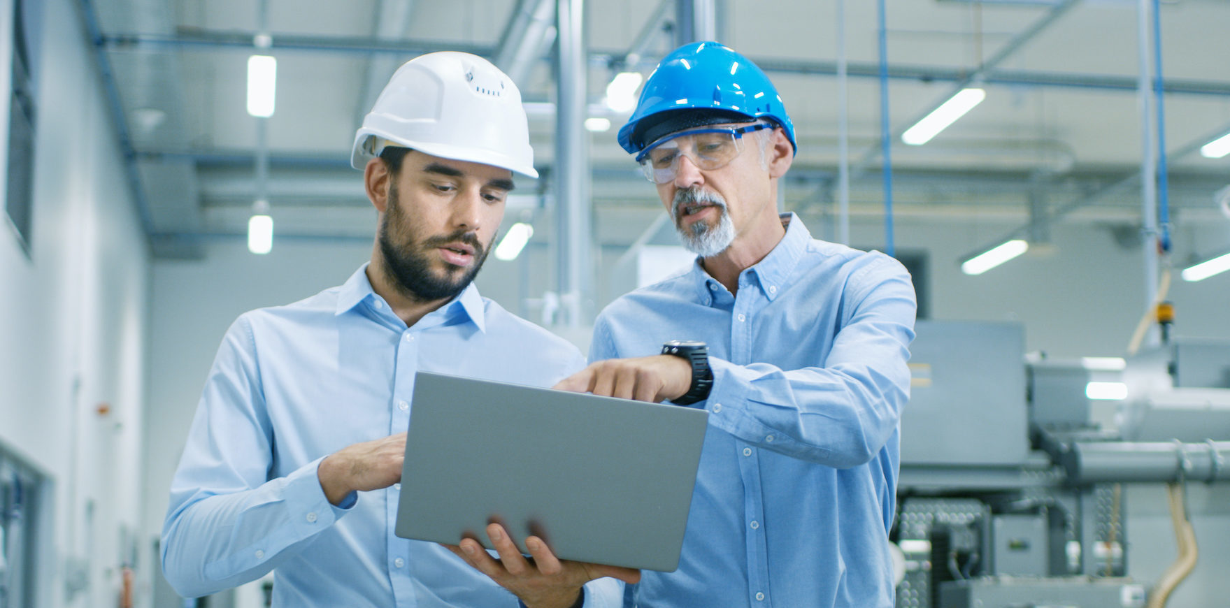 Head of the Project Holds Laptop and Discusses Product Details with Chief Engineer while They Walk Through Modern Factory.