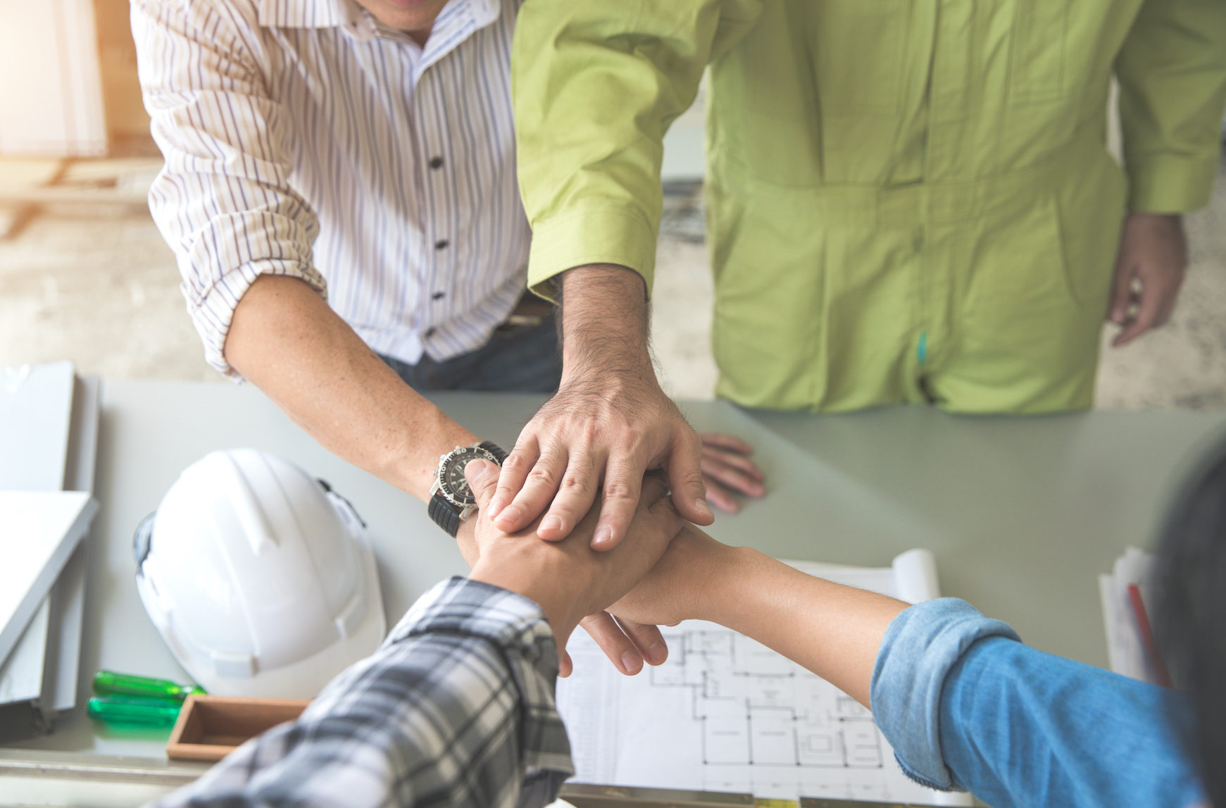 Portrait of engineer people stacking hands after finish successful project at construction site